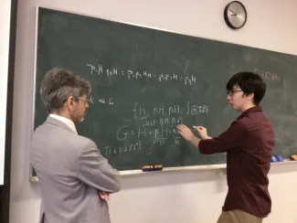 Two people at a chalk board